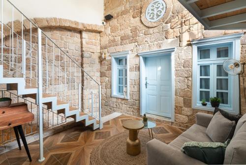 a living room with stairs and a stone wall at Villa Sera in ‘Akko