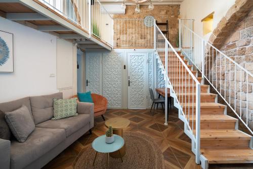 a living room with a couch and a staircase at Villa Sera in ‘Akko