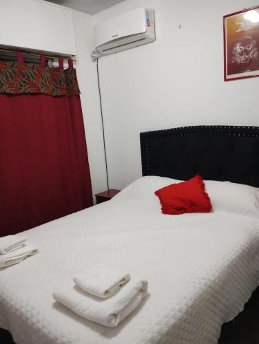 um quarto com uma cama branca com duas toalhas em Departamento Blanca em Mendoza