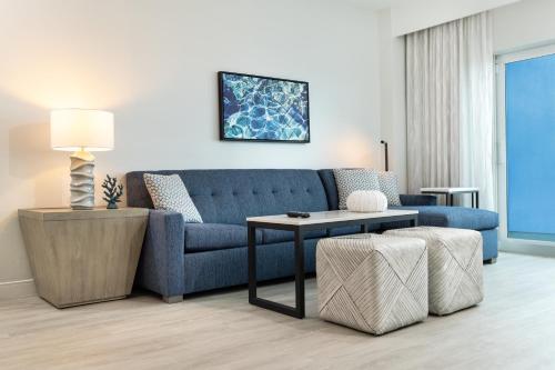 a living room with a blue couch and a table at Ocean Place Resort & Spa in Long Branch