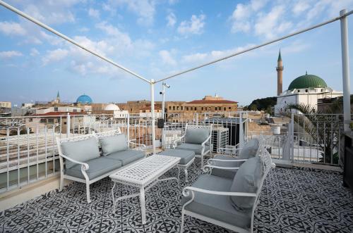 a balcony with chairs and a view of a city at Villa Sera in ‘Akko