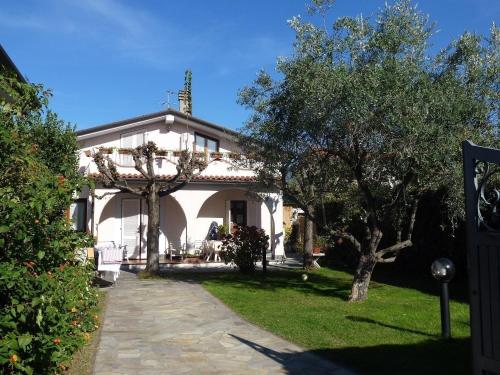 uma casa branca com árvores em frente em Villa im bekannten Strandort Forte dei Marmi mit schönem Garten und ruhig gelegen em Forte dei Marmi