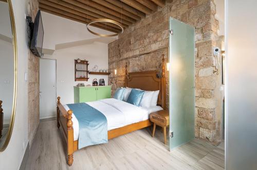 a bedroom with a bed and a stone wall at Villa Sera in Acre
