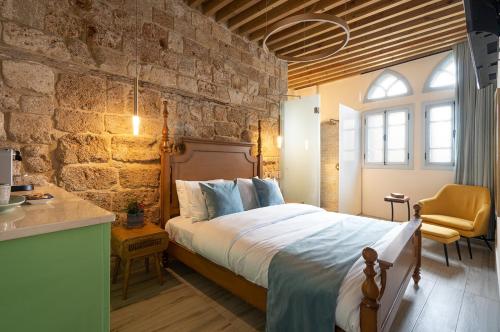 a bedroom with a bed and a stone wall at Villa Sera in ‘Akko