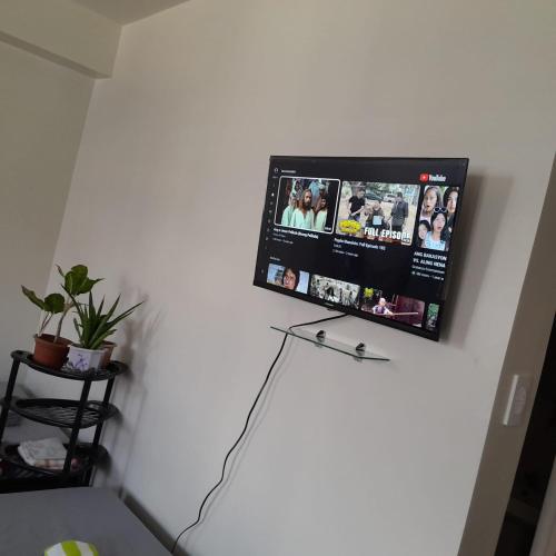 a tv hanging on a white wall in a room at Family room Casa Mia at SMDC Styles Residence Tower A in Iloilo City