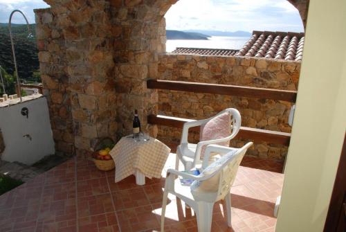 um pátio com 2 cadeiras, uma mesa e uma janela em Ferienhaus in Torre Dei Corsari mit Terrasse und Meerblick - b56406 em Torre dei Corsari