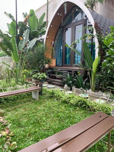 a garden with a bench in front of a building at Mio Hotel in Hải Dương
