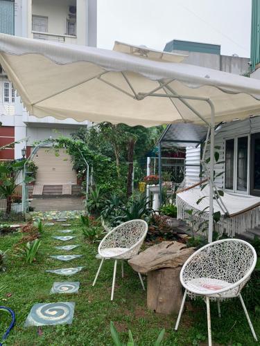 a patio with two chairs and an umbrella at Mio Hotel in Hải Dương