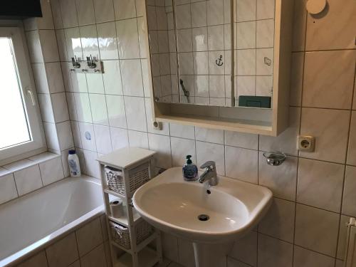 La salle de bains est pourvue d'un lavabo et d'une baignoire. dans l'établissement Ferienwohnung „Landidylle“, à Stemwede