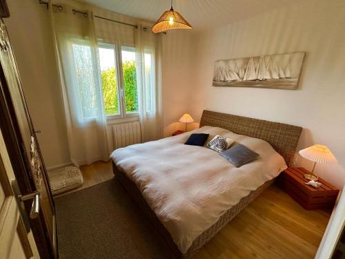 a bedroom with a large bed in front of a window at Maison de vacances in Olonne-sur-Mer