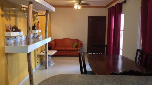 ein Wohnzimmer mit einem Tisch und einem roten Sofa in der Unterkunft Residencial espinal 2 in Punta Cana
