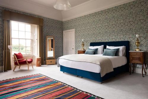 a bedroom with a large bed and a chair at Papple Farmhouse at Papple Steading in East Linton