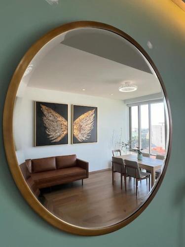 a living room with a table and a mirror at Olivo&Laurel HP - Sur in Mexico City
