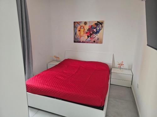 1 dormitorio con 1 cama roja y 2 mesitas de noche en One bedroom apartment Msida, en Msida