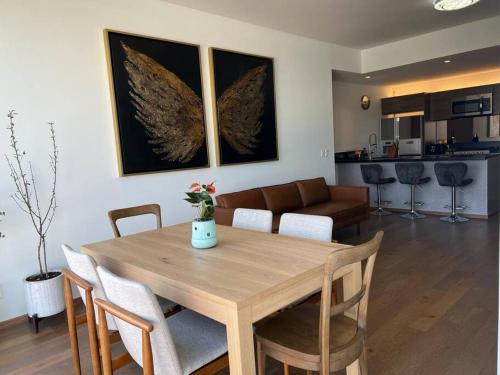 a dining room and living room with a table and chairs at Olivo&Laurel HP - Sur in Mexico City
