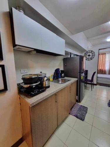uma cozinha com um fogão, um lavatório e um frigorífico em Cute and Cozy Solo 1 bedroom Condo unit in Baguio em Baguio