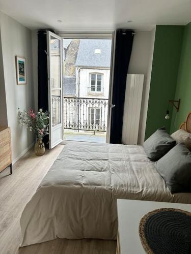 une chambre avec un grand lit et une grande fenêtre dans l'établissement Terasse avec superbe vue sur le marché de Dieppe, à Dieppe