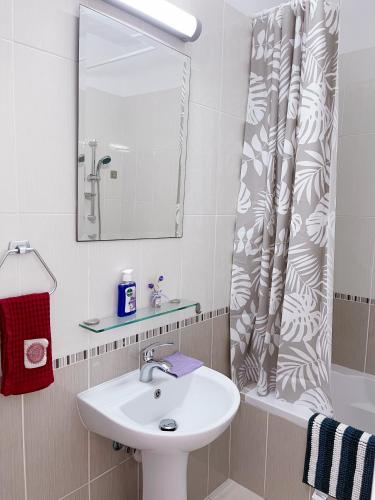 a bathroom with a sink and a shower curtain at Elysia Park in Paphos