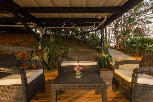 a patio with chairs and a table with flowers on it at Casa Pelícano - Tropical house w' private pool and ocean views in Playa Venao