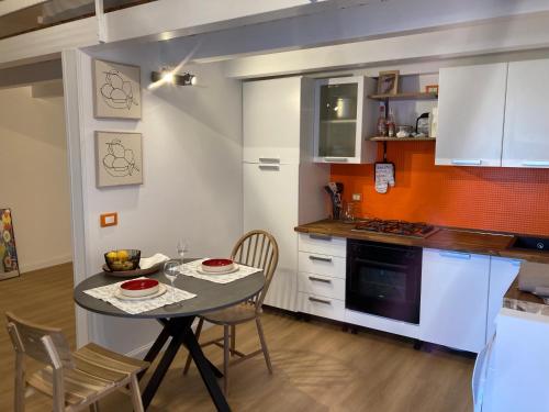 a kitchen with a table and chairs and a kitchen with white cabinets at Lavica Di Mezzo Apartments in Catania