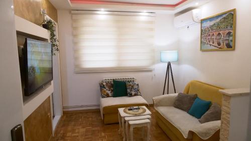 - un salon avec un canapé et une télévision dans l'établissement Apartment M, à Višegrad