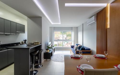 cocina y sala de estar con mesa en una habitación en LOCAR-IN GRAMADO- Maria Antonia, en Gramado