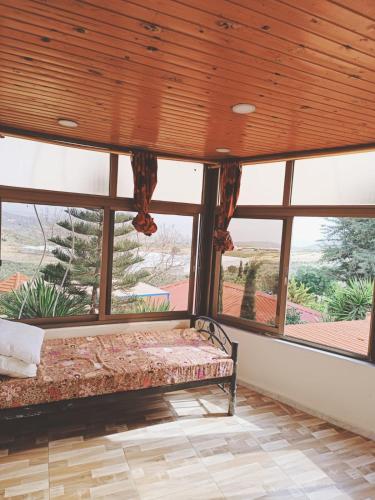 sypialnia z łóżkiem i dużymi oknami w obiekcie شاليه للايجار اليومي والاسبوعي w mieście Amman