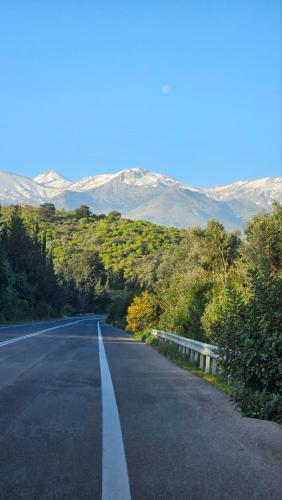 an empty road with trees and mountains in the background at Gardenia - Morfi Village with pool in Exopoli