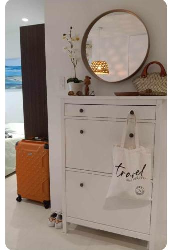 a dresser with a mirror and a bag on it at Studio condo unit at Tambuli Seaside Resort in Lapu Lapu City