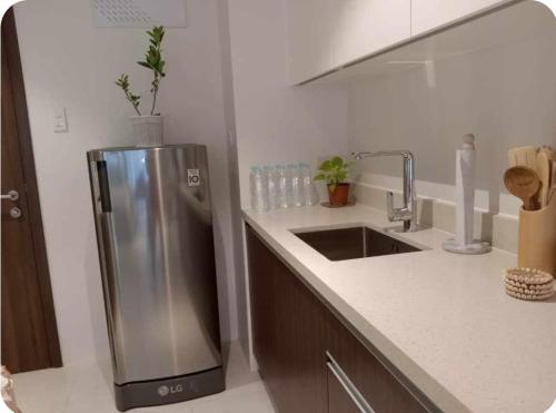 a kitchen with a stainless steel refrigerator next to a sink at Studio condo unit at Tambuli Seaside Resort in Lapu Lapu City