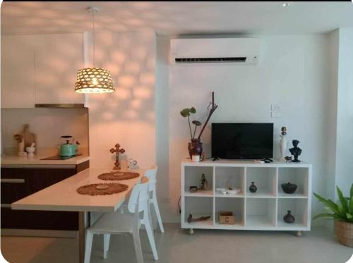 a kitchen with a table with chairs and a television at Studio condo unit at Tambuli Seaside Resort in Lapu Lapu City
