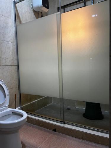 a bathroom with a glass shower stall with a toilet at Close 5 in Garki