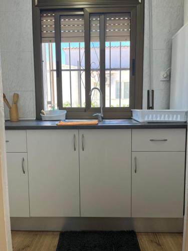 a kitchen counter with a sink and a window at Casa en empuriabrava in Empuriabrava