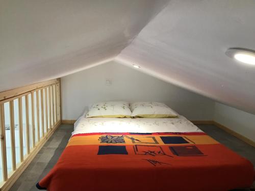 une chambre avec un lit avec une couverture orange dans l'établissement Super studio coup de cœur, à Niort