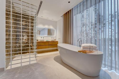 a bathroom with a tub and a large window at Green House - Modern Villa in Tenerife, Spain in Guía de Isora