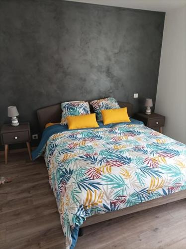 - une chambre avec un lit doté d'un couvre-lit coloré dans l'établissement Le P'tit Courtil - Maison à la campagne, à Plédran