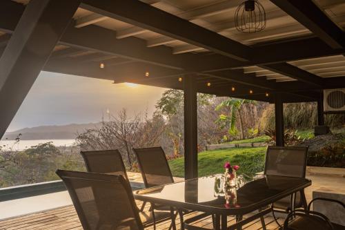 a table and chairs on a patio with a view of the ocean at Casa Pelícano - Tropical house w' private pool and ocean views in Playa Venao