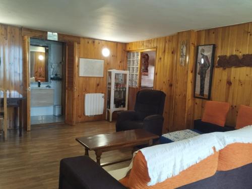 a living room with a bed and a table at Casa LLANO43 Lago & Montaña in Las Rozas de Valdearroyo