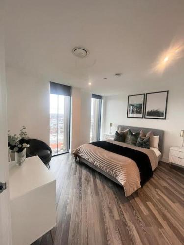 a bedroom with a large bed in a white room at Opulent 3 -Bedroom Penthouse with Stunning Views in Newcastle upon Tyne