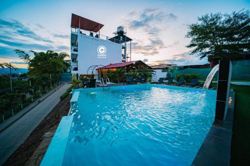 una piscina con cascata di fronte a un edificio di Tarapoto central suites a Tarapoto