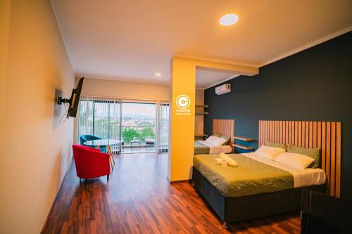 una habitación de hotel con 2 camas y una silla roja en Tarapoto central suites, en Tarapoto