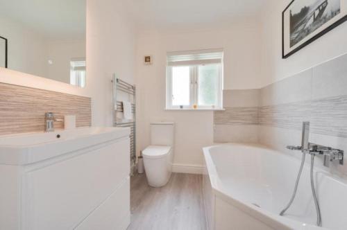 y baño con bañera, aseo y lavamanos. en 3 Bed Holiday Home in Llandeilo with log burner en Llandeilo