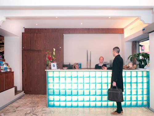 a man standing in front of a bar at Hôtel Esprit d'Azur in Nice