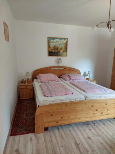 1 dormitorio con cama de madera en una habitación en Lonci apartman, en Zalakaros