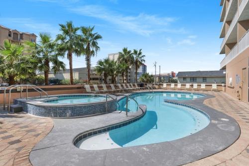 a swimming pool with palm trees and a building at Crystal Tower 206 Amenities galore in Gulf Shores