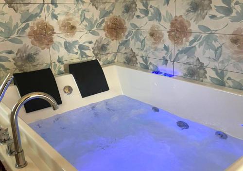 a bathroom with a bath tub with a blue sink at Villa Marlene Casa vacanze in parco privato in Monterusciello