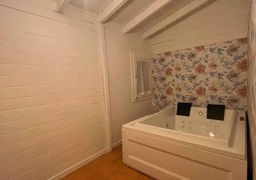 a white bathroom with a tub in a room at Villa Marlene Casa vacanze in parco privato in Monterusciello