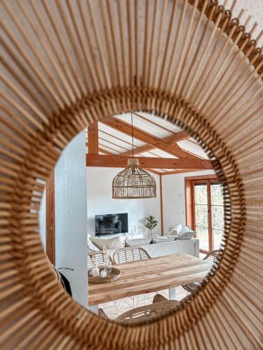 a mirror reflecting a living room and a dining room at Boho Beach House De Haan in De Haan