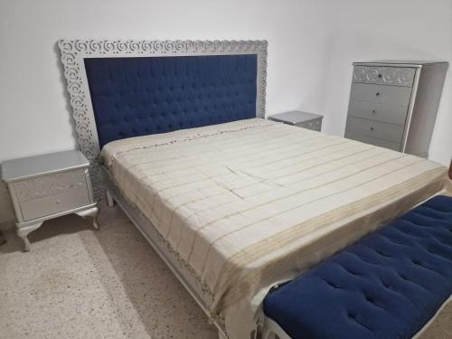 una camera con un grande letto con testiera blu di Dar Salem III a Tunisi