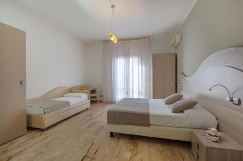 a bedroom with two beds and a table in it at La Conchiglia sul mare Hotel in San Vito lo Capo